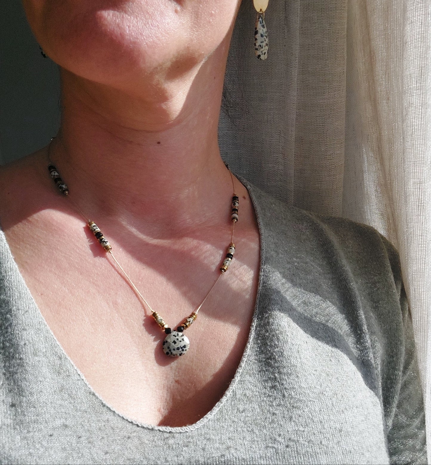 Femme portant un collier sautoir en pierre naturelle de jaspe dalmatien, bijou bohème réglable
