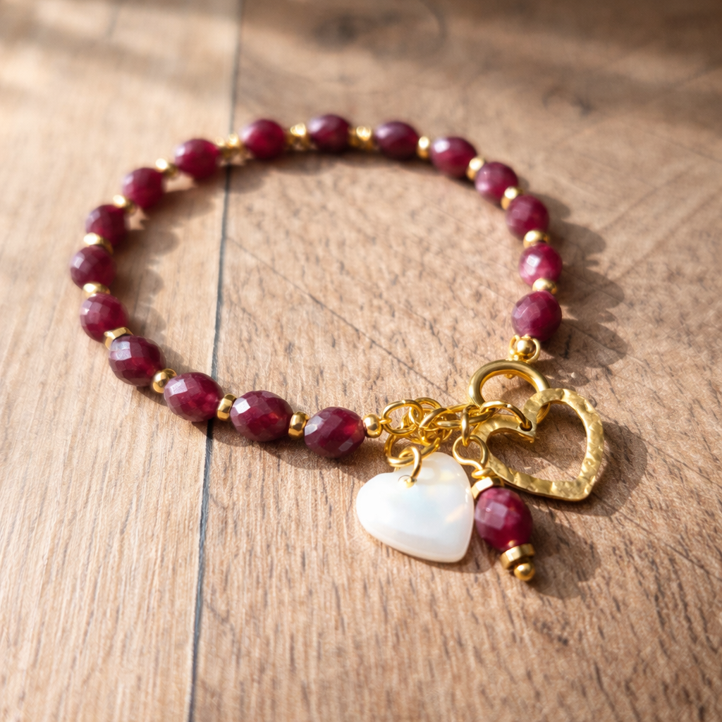 bracelet grenat bohème posé sur fond naturel, perles grenat naturelles, pendentifs cœur acier inoxydable 316L et nacre blanche, bijou artisanal élégant inspiration nature