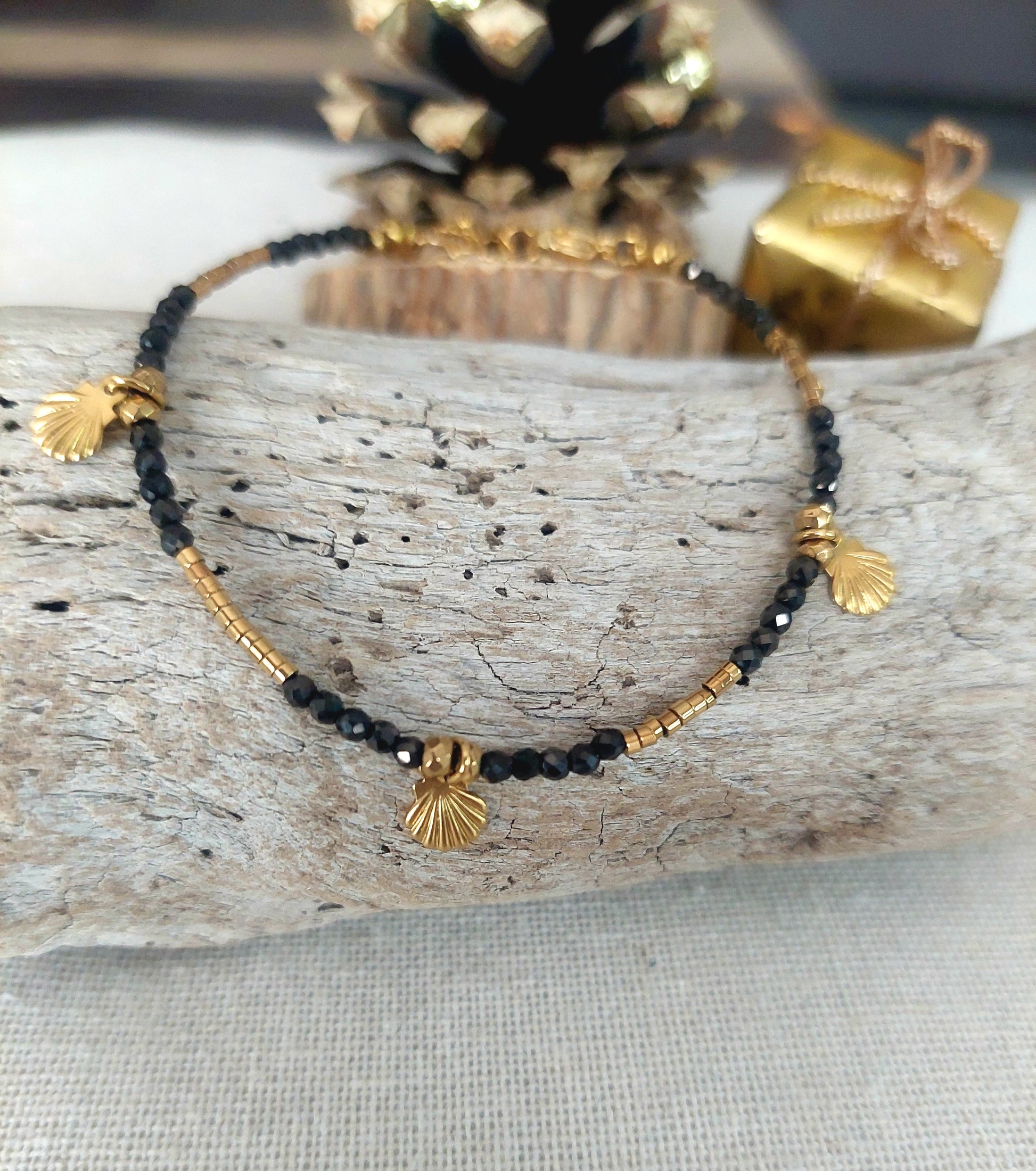 Bracelet élégant avec cristaux, hématites dorées et pampilles coquillages présenté à plat