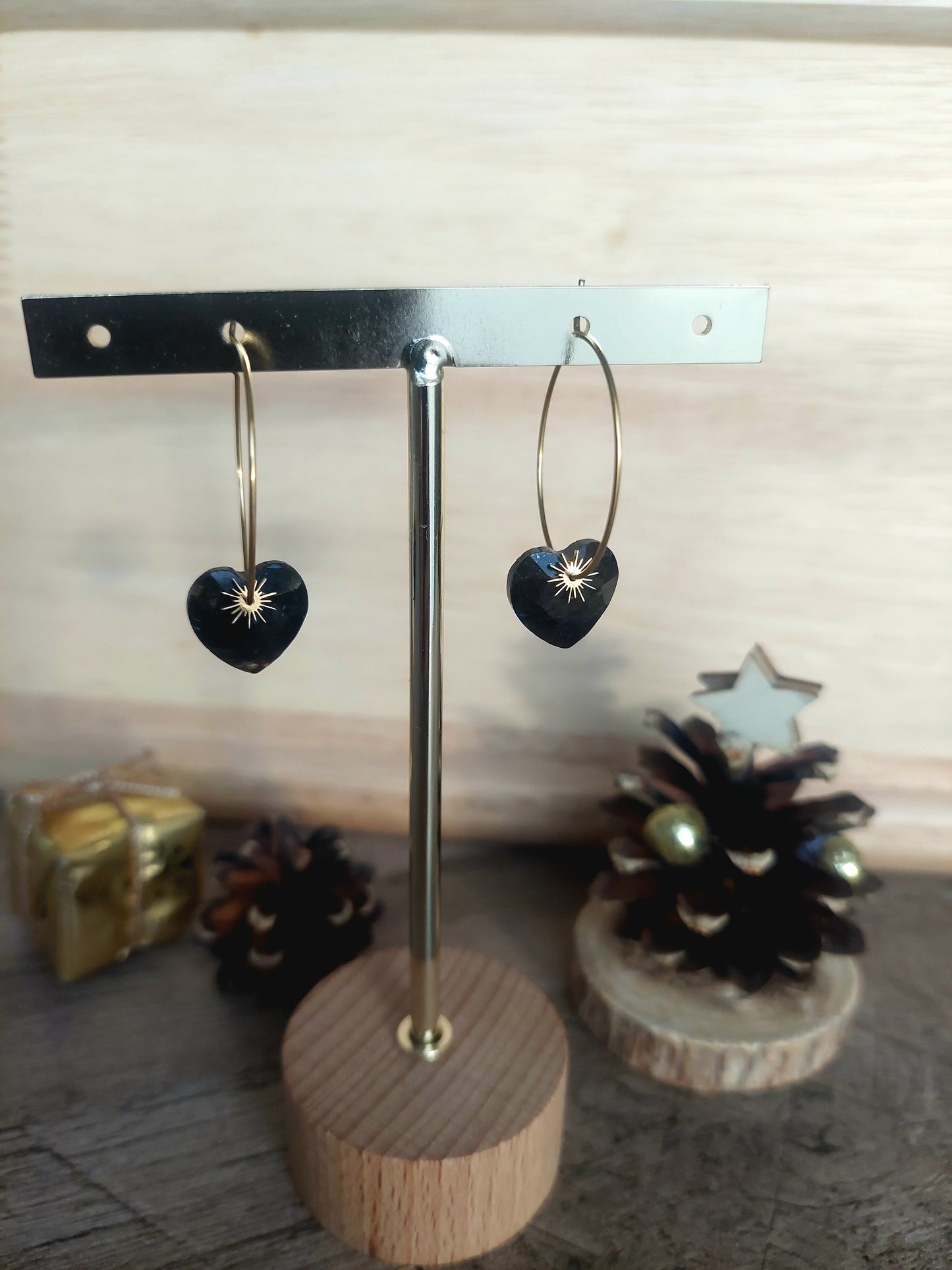 Boucles d’oreilles dorées photographiées sur un décor minimaliste et chaleureux.