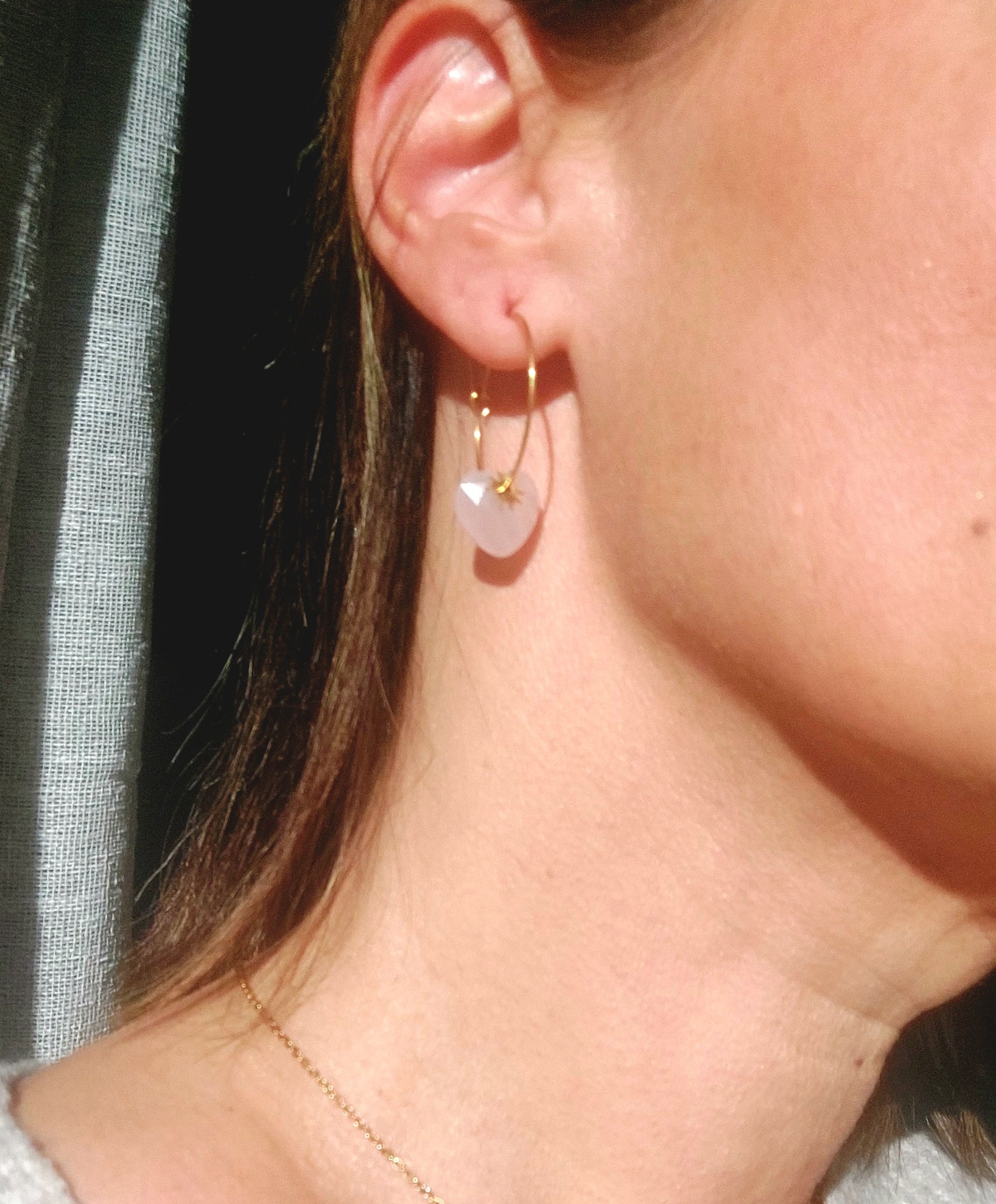 Créoles bohèmes en quartz rose naturel portées, finition acier inoxydable doré, style chic et moderne.