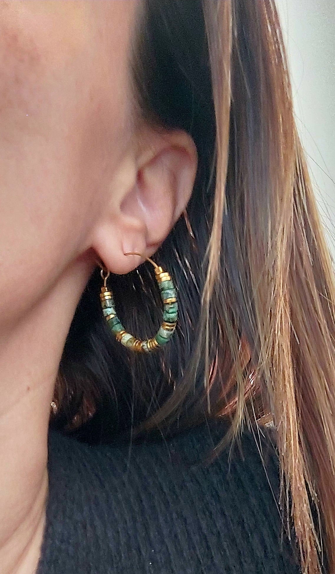 Boucles d’oreilles créoles en perles heishi turquoises africaines portées en gros plan de profil, mettant en valeur les détails du bijou bohème fait main, élégant et unique.