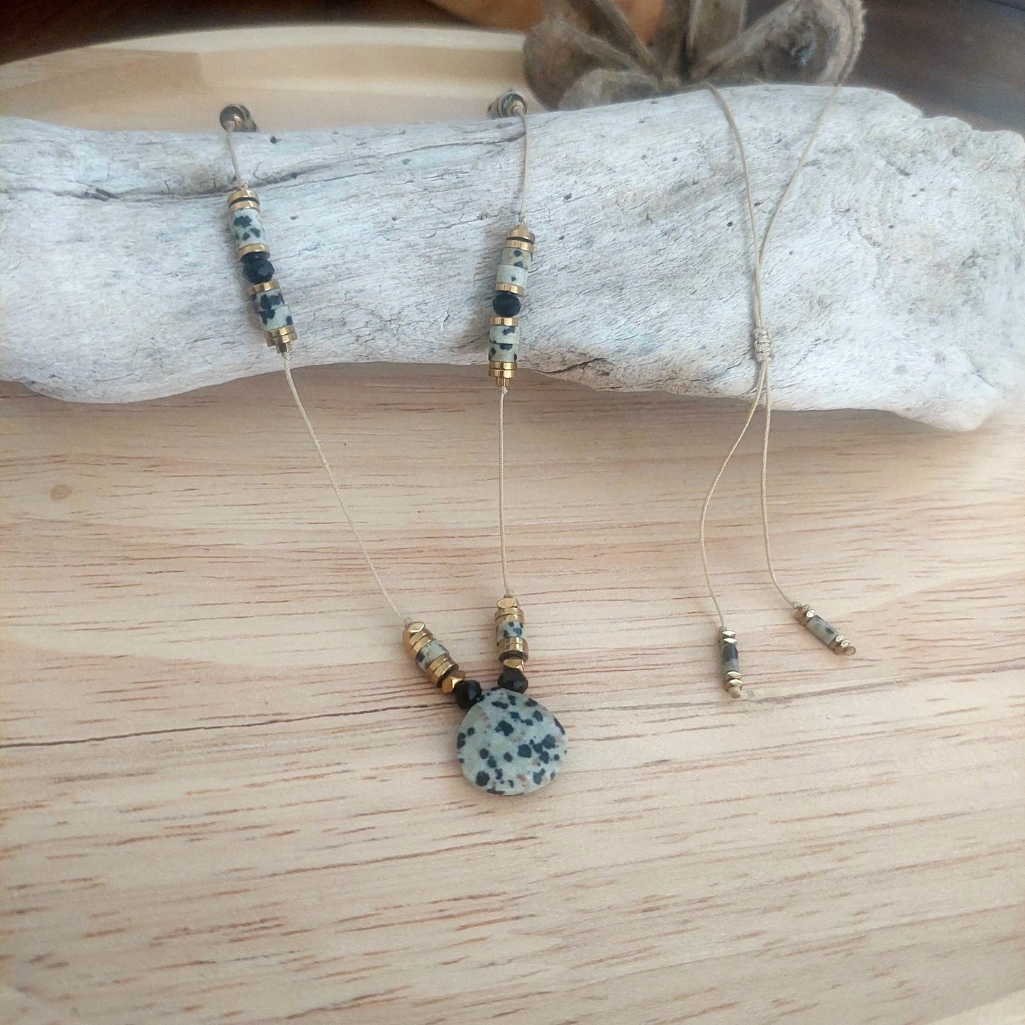 Sautoir artisanal jaspe dalmatien présenté sur support, bijou unique en pierre naturelle