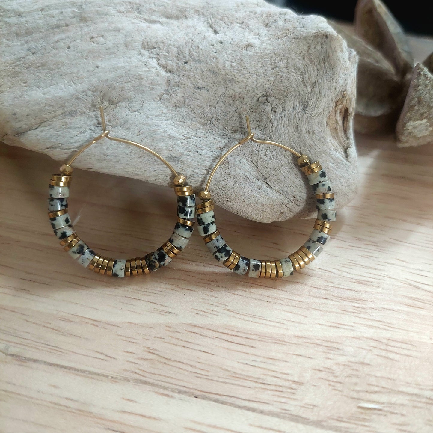 Créoles acier inoxydable avec perles jaspe dalmatien naturel, boucles d’oreilles artisanales exposées sur support clair