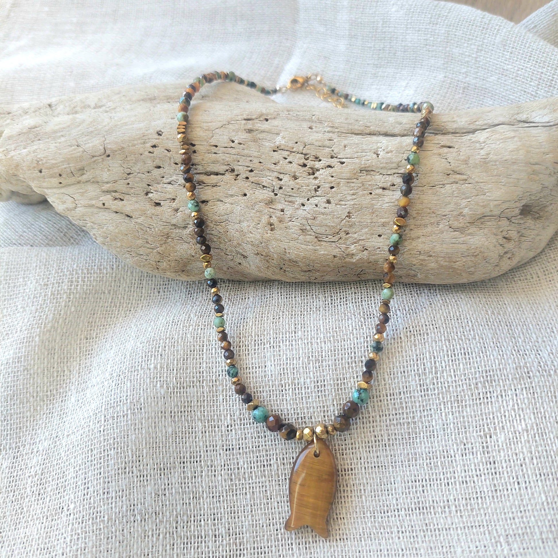 Zoom sur collier bohème œil de tigre et turquoise africaine avec pendentif poisson sculpté en œil de tigre