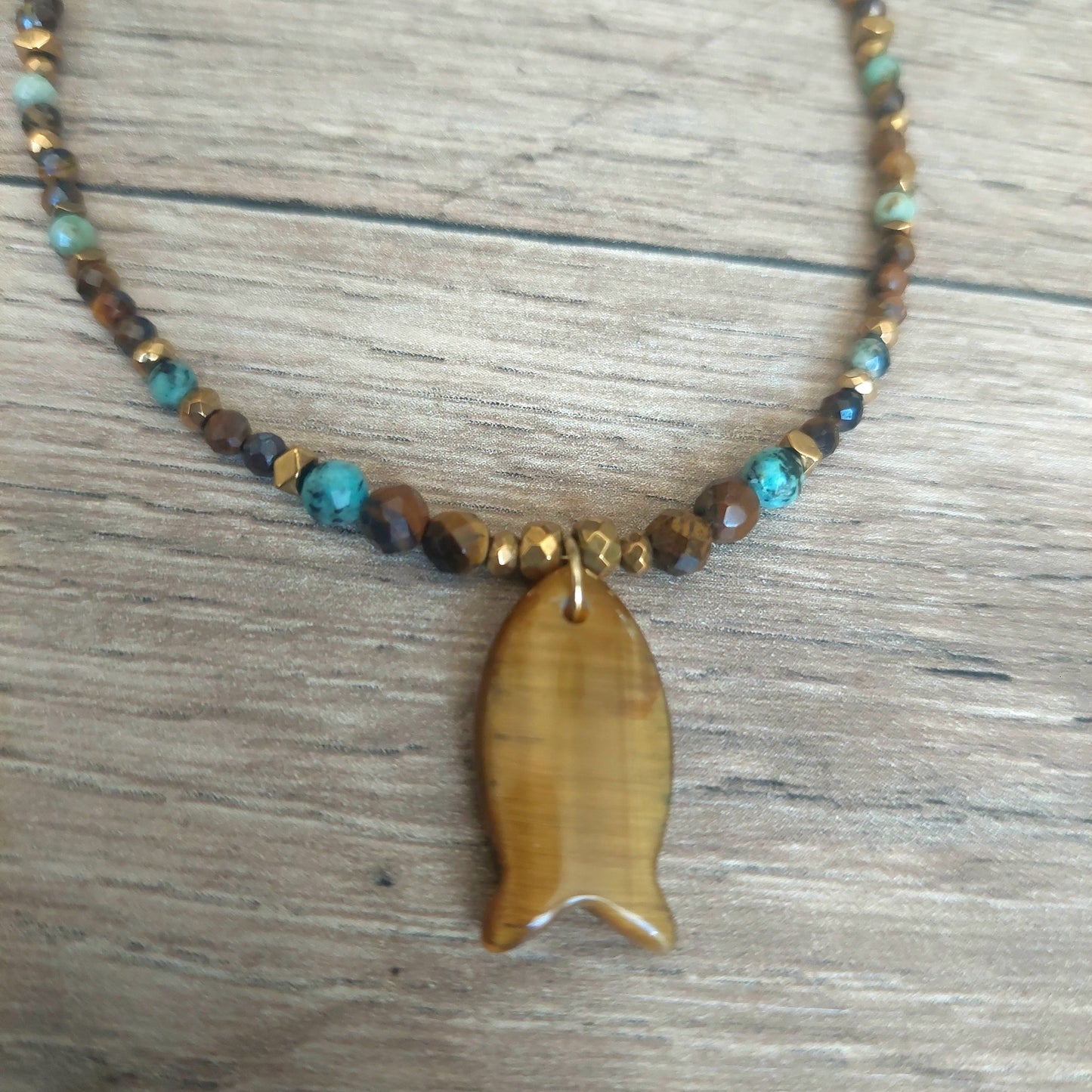 Détail pendentif poisson en œil de tigre sur collier en pierres naturelles