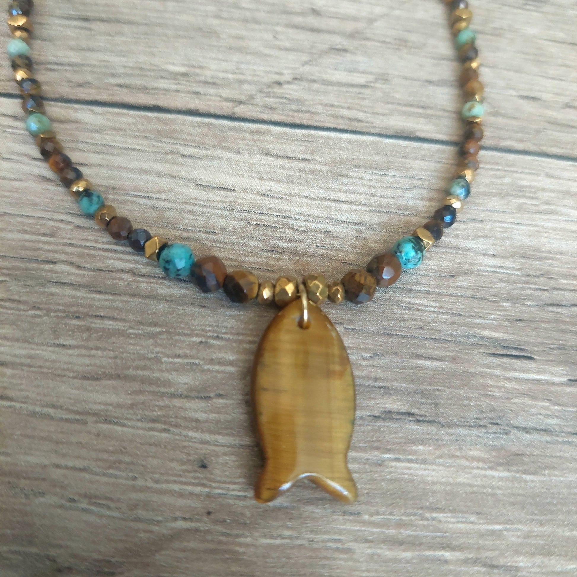 Détail pendentif poisson en œil de tigre sur collier en pierres naturelles