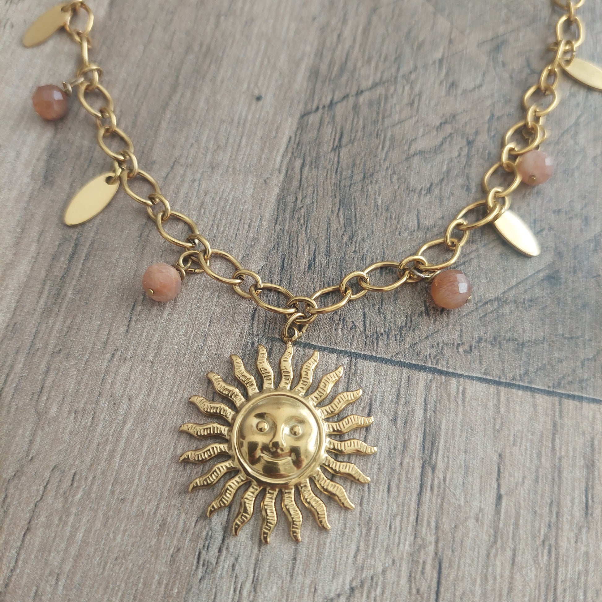 Gros plan collier bohème acier inoxydable pendentif soleil et pierres de soleil naturelles, détails du bijou fait main