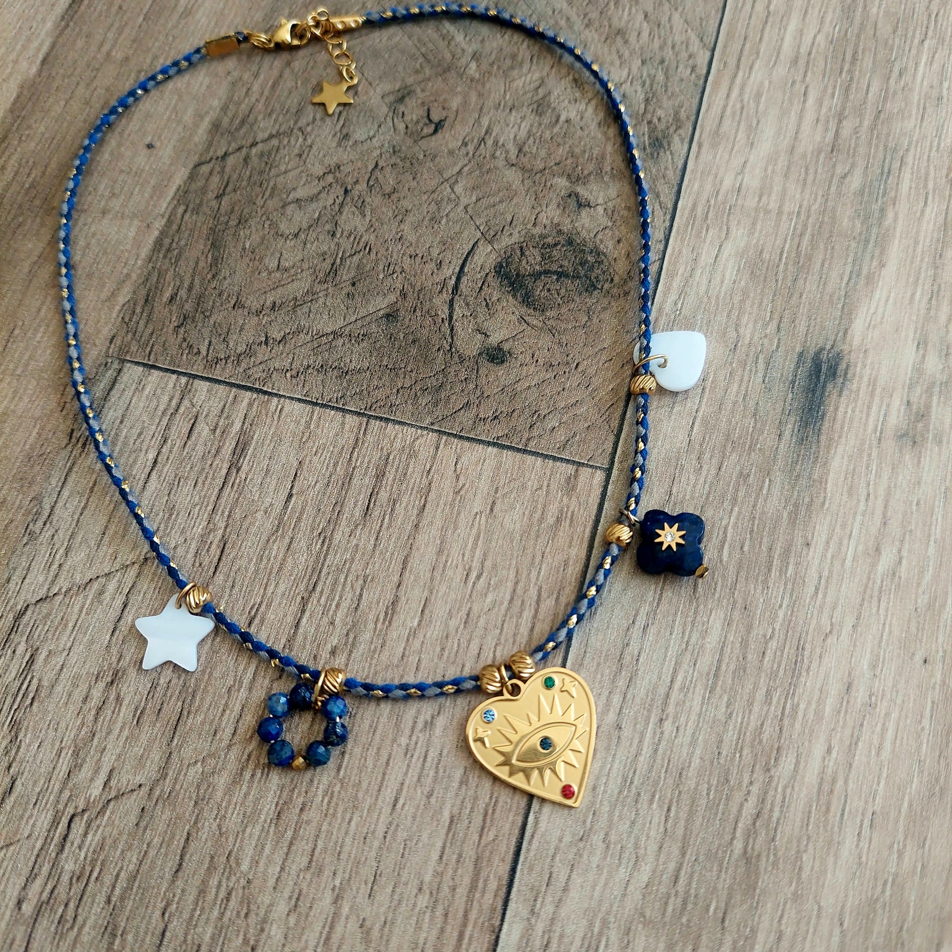 Collier bohème femme en cordon bleu roi avec pendentif cœur en acier inoxydable, nacre et lapis-lazuli sur fond naturel bijou fait main