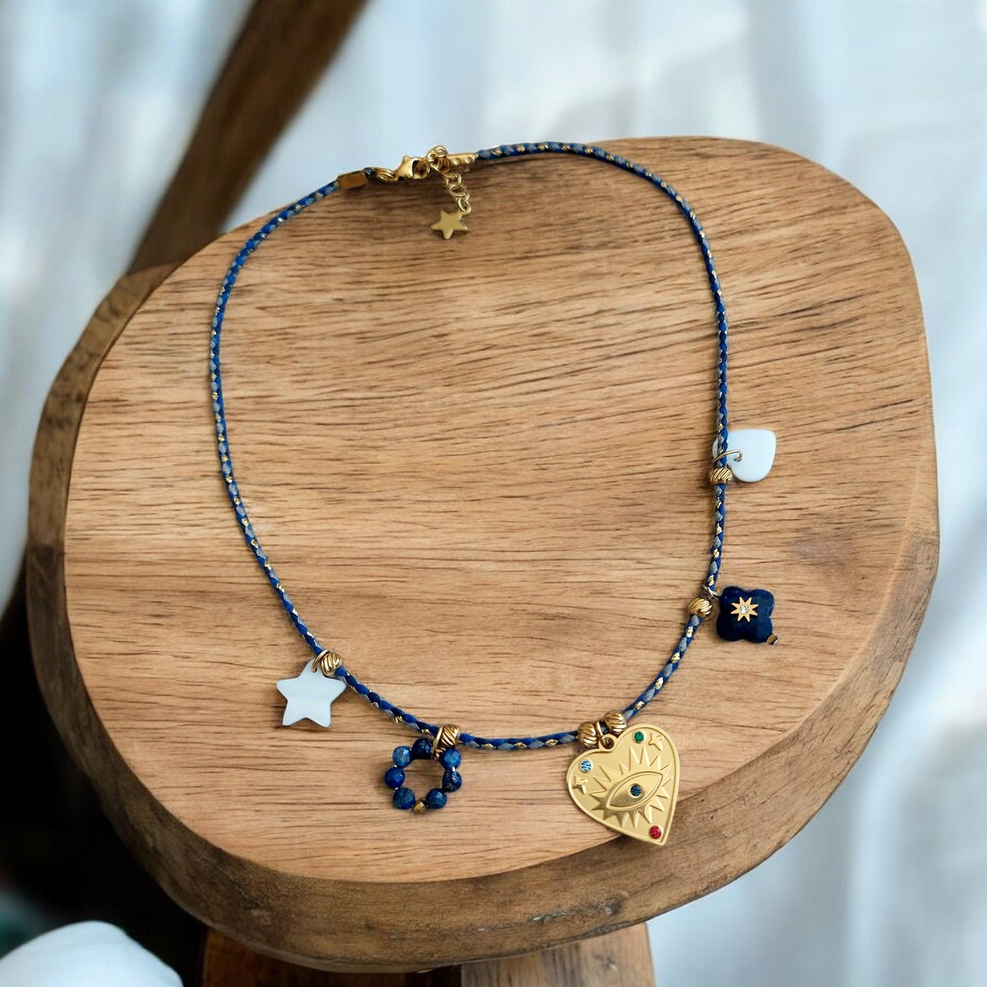 Collier bohème cordon bleu roi avec pendentif cœur en acier inoxydable, nacre et lapis-lazuli posé sur présentoir