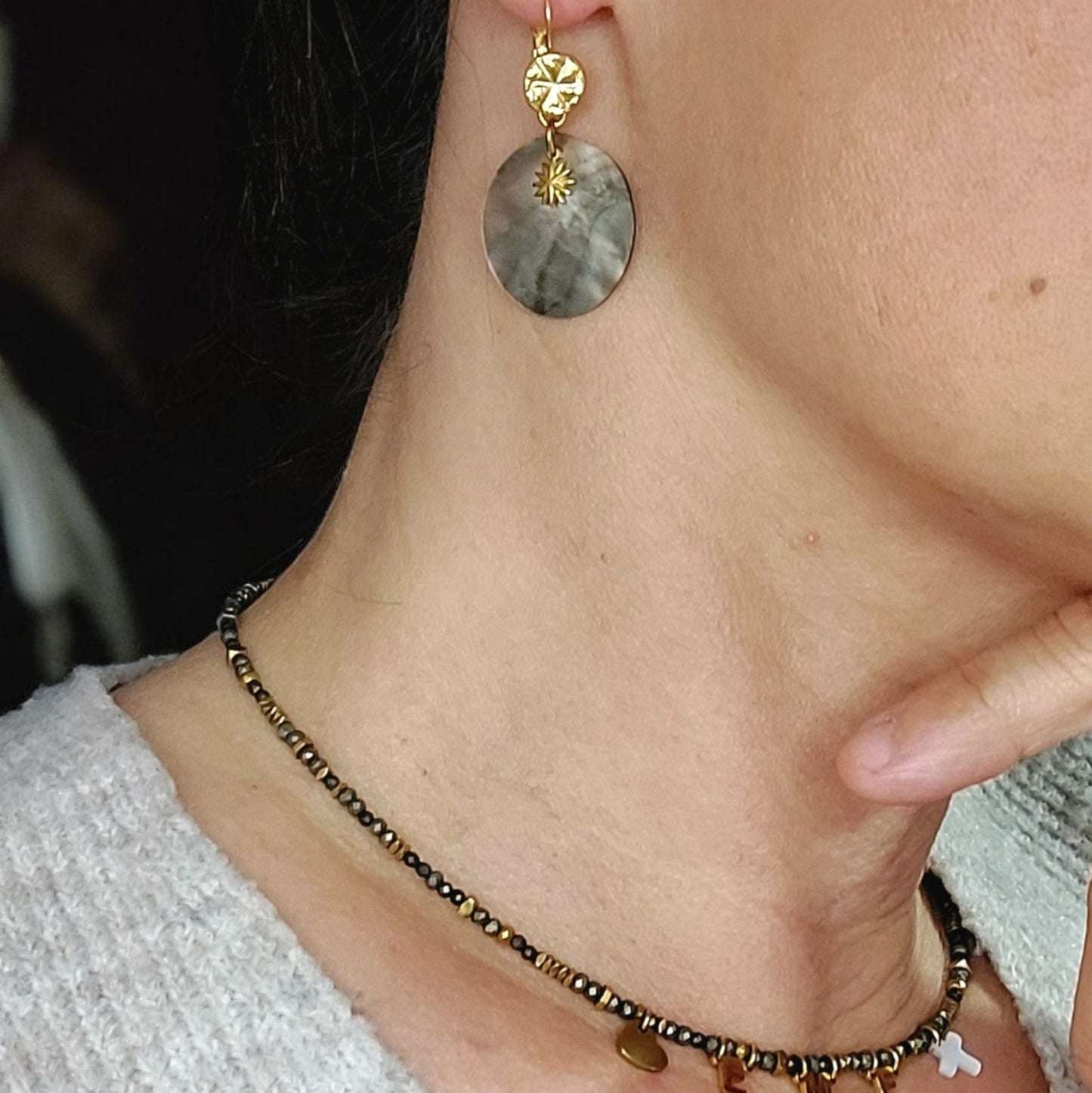 Boucles d’oreilles élégantes portées avec pendentif nacre et soleil