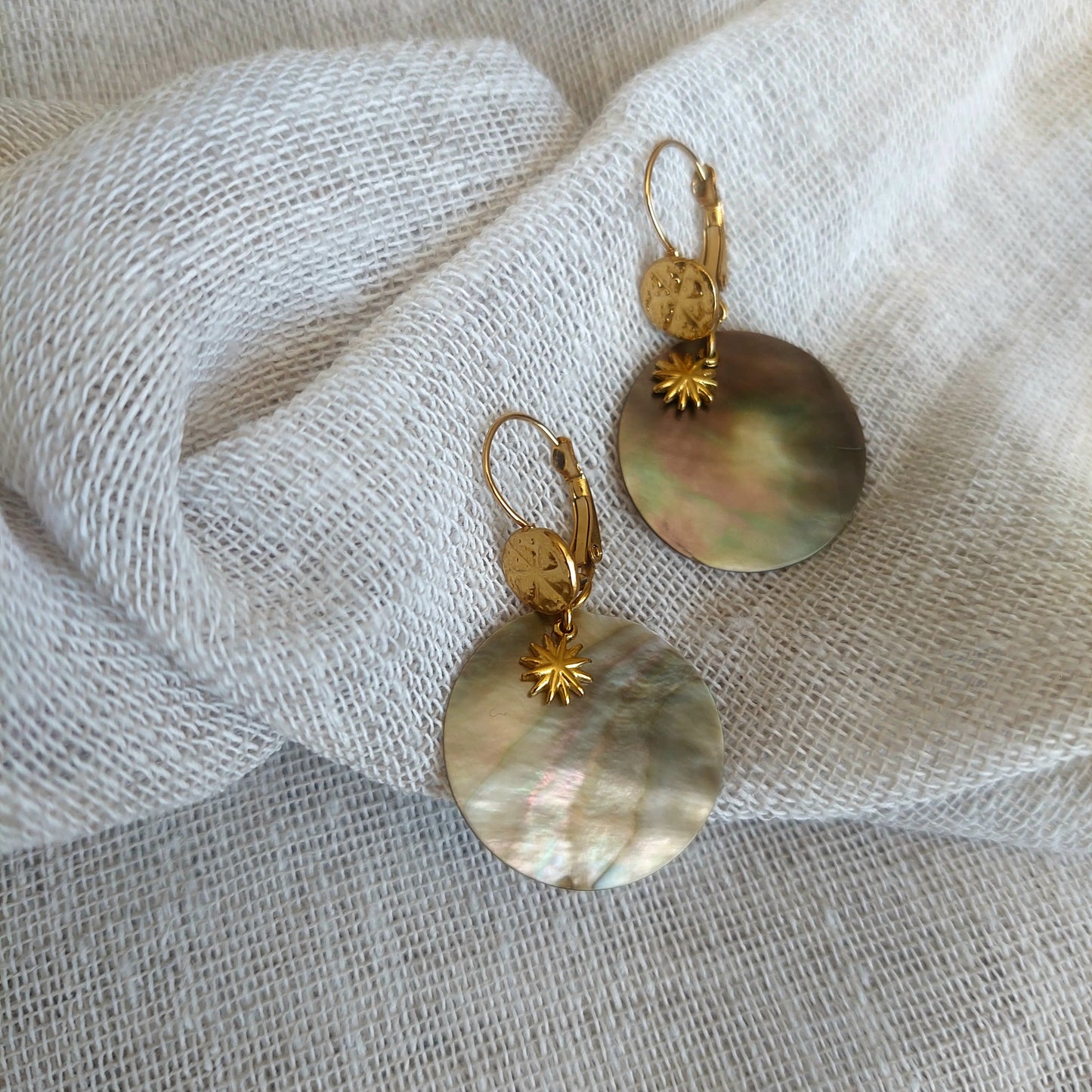 Boucles nacre et soleil en acier inoxydable présentées sur fond clair bijou bohème