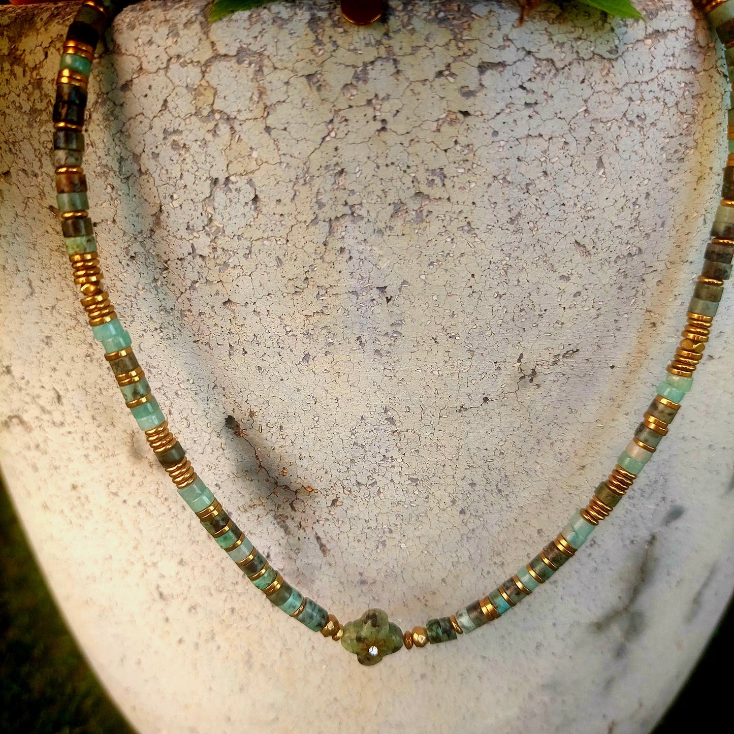 Bijou unique entièrement fait main exposé à la lumière du jour pour mettre en valeur les couleurs des pierres naturelles 