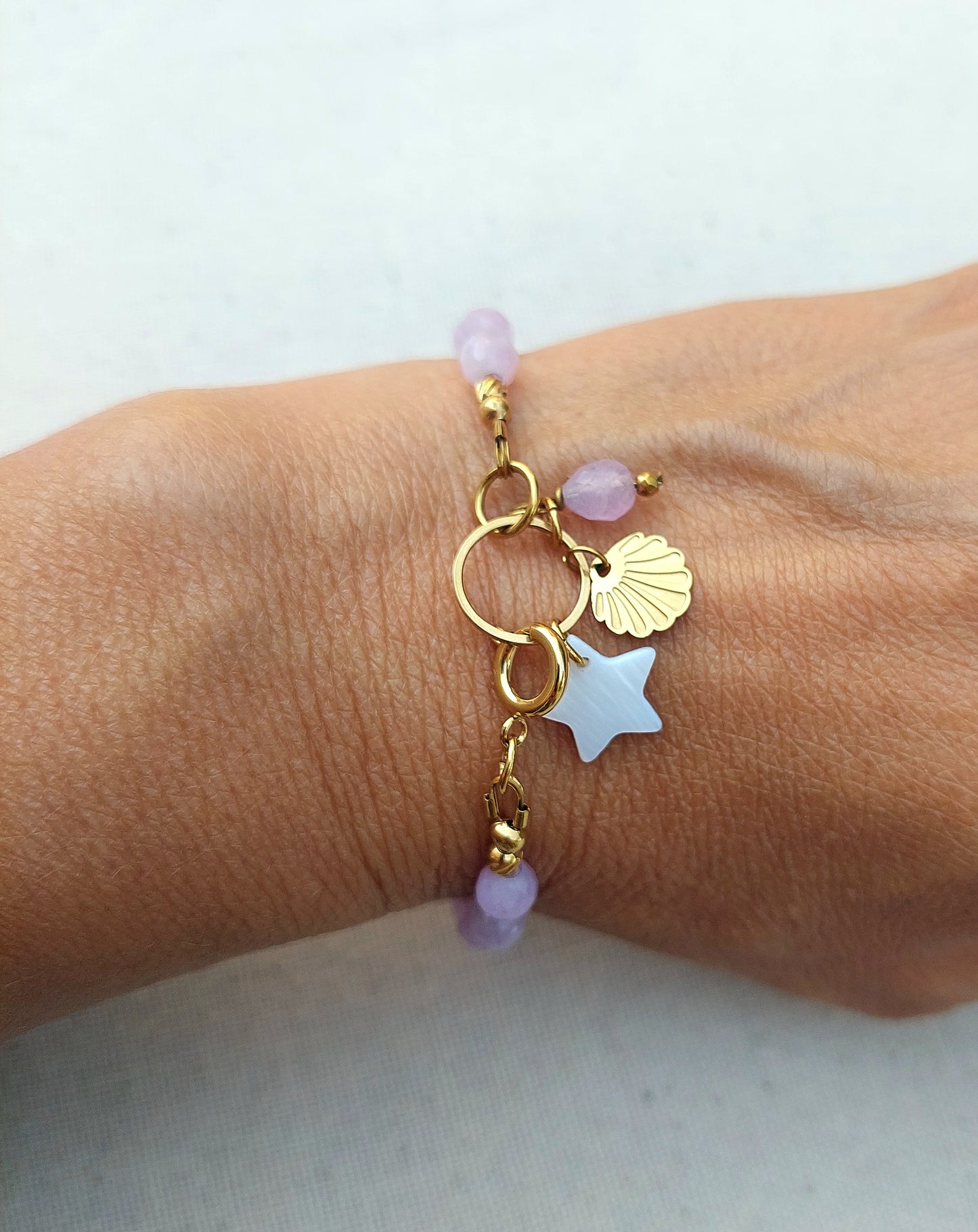 Bracelet Alba en kunzite naturelle, acier inoxydable doré 316L et étoile en nacre porté au poignet. Style bohème pour femme