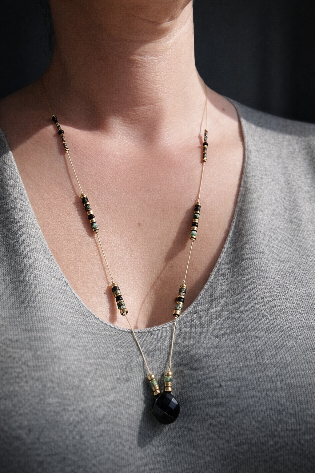 Collier sautoir turquoise africaine avec pendentif agate noire porté autour du cou