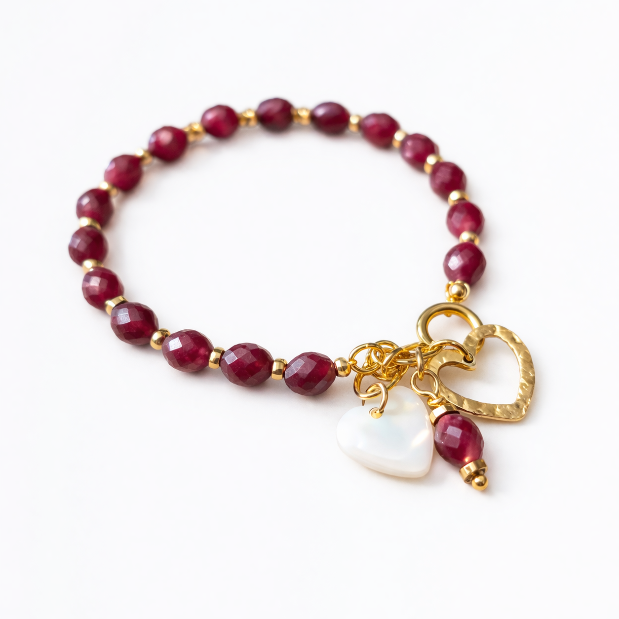 bracelet bohème femme  en grenat  sur fond blanc, perles grenat naturelles, pendentifs cœur acier inoxydable 316L et nacre blanche, bijou artisanal élégant et minimaliste