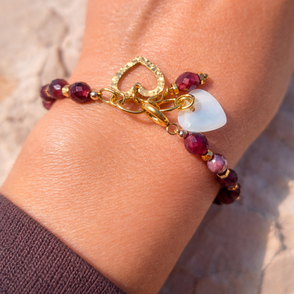bracelet en grenat porté au poignet, bijou bohème chic, perles grenat naturelles, pendentifs cœur acier 316L et nacre blanche, création artisanale féminine élégante