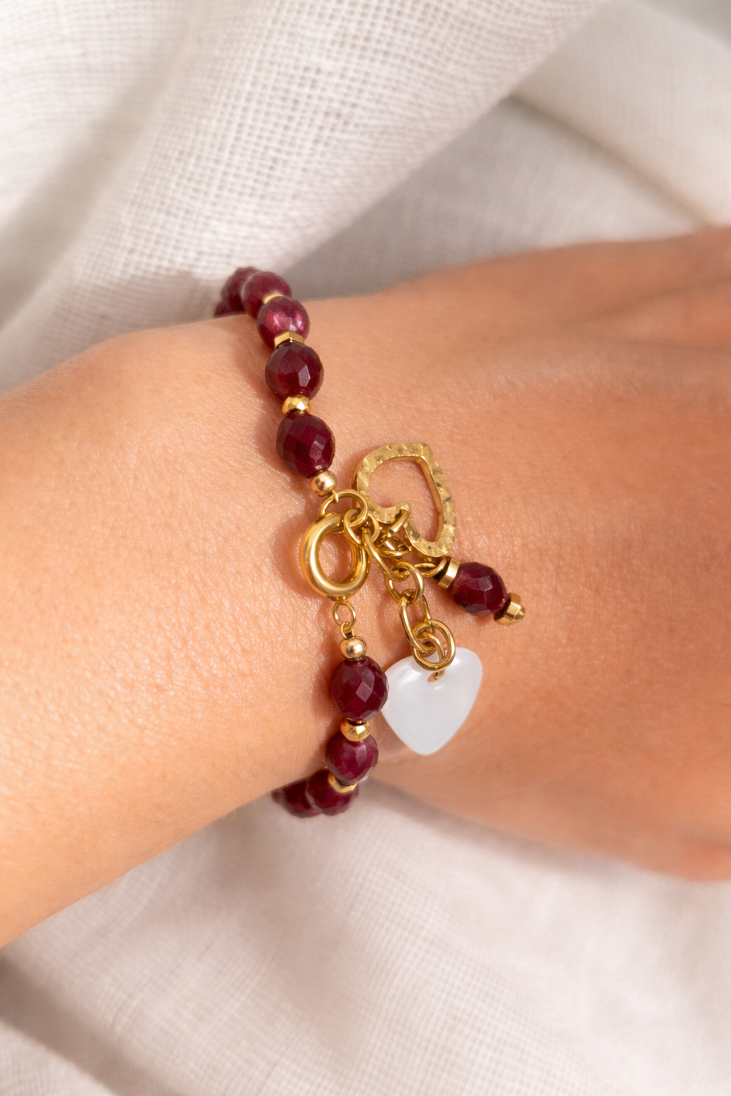 bracelet grenat bohème porté, bijou femme élégant, perles grenat naturelles, double pendentif cœur acier inoxydable 316L et nacre blanche, accessoire artisanal raffiné