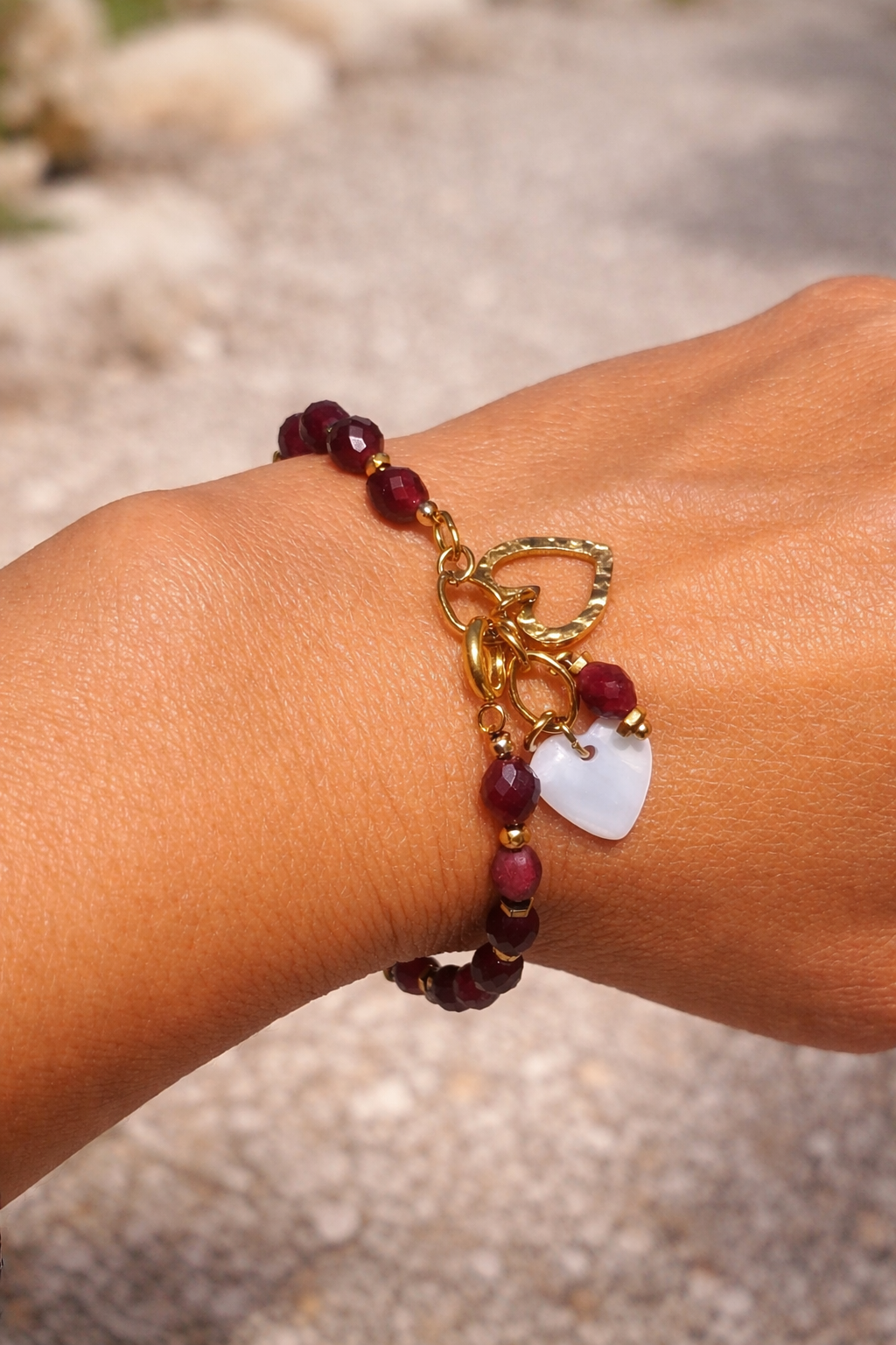 bracelet bohème grenat porté, perles naturelles grenat, pendentif cœur acier inoxydable 316L, cœur nacre blanche, bijou artisanal élégant femme