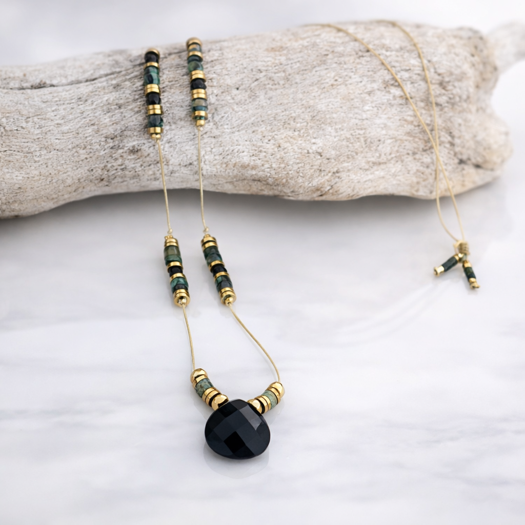 Collier sautoir en turquoise africaine et pendentif agate noire exposé sur support fond clair