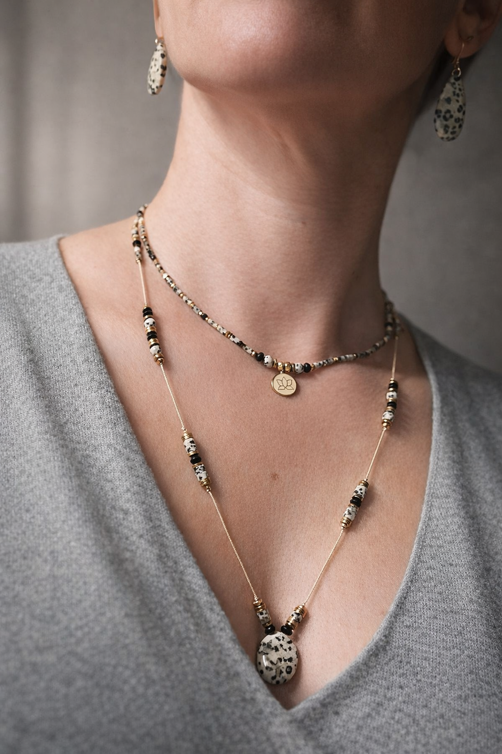 Collier bohème en jaspe dalmatien porté en accumulation avec un collier ras de cou bohème, cordon réglable avec nœud coulissant 